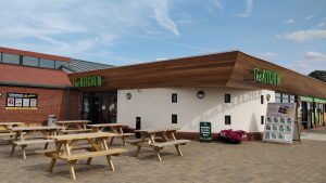 Grange Leisure Park near Mablethorpe, Lincolnshire, featuring The Kitchen cafe with a sun terrace, designed by Norfolk architects Paul Robinson Partnership. The development includes a new entrance foyer, function room, bar, restaurant, shop, and landscaped surroundings