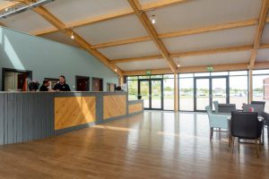 Spacious reception area at Grange Leisure Park near Mablethorpe, Lincolnshire, featuring timber beams, large windows, and modern furnishings, designed by Norfolk architects Paul Robinson Partnership