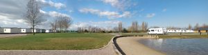 Panoramic view of Grange Leisure Park near Mablethorpe, Lincolnshire, showcasing caravans, open green spaces, and a sandy lakeside area. Designed by Norfolk architects Paul Robinson Partnership, Phase 2 will expand the facilities to include a swimming pool complex, spa, and outdoor terrace
